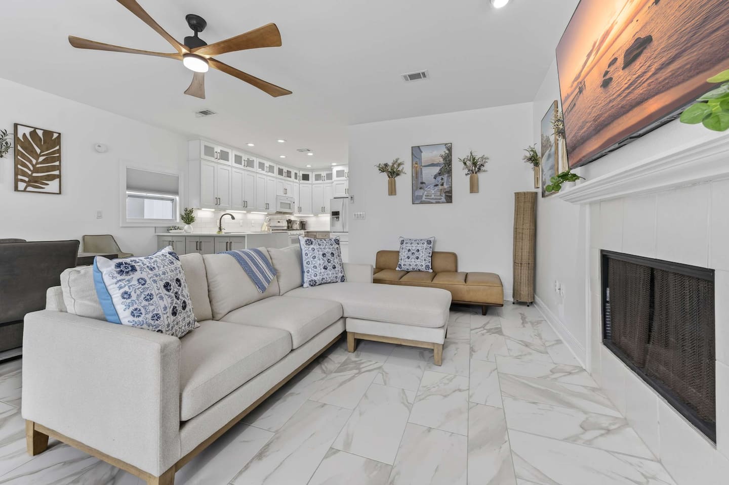 Modern kitchen featuring white cabinetry, stainless steel appliances, and marble flooring, designed for guest comfort.