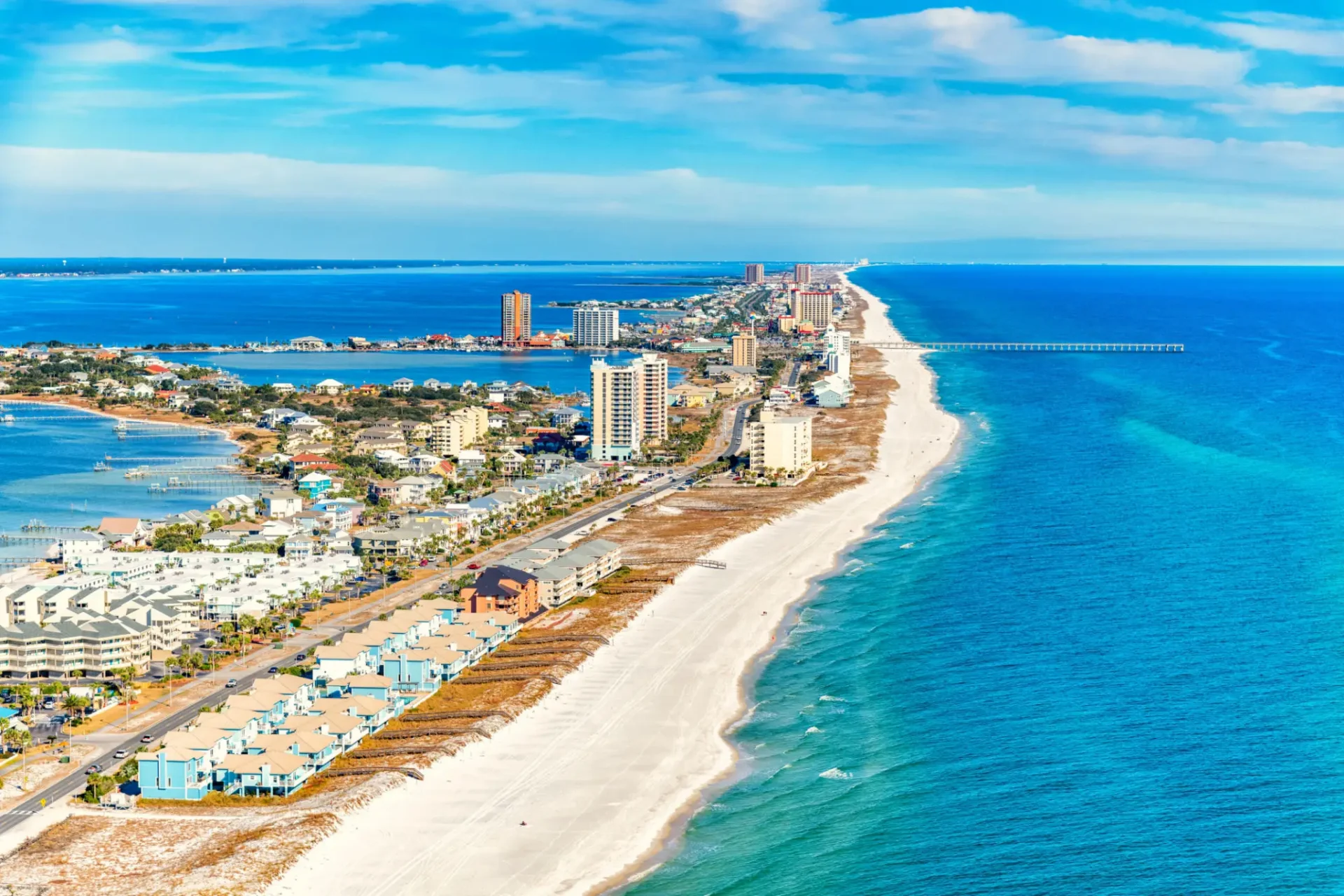 Coastal view showcasing sandy beaches, vibrant neighborhoods, and a serene blue ocean under a clear sky.