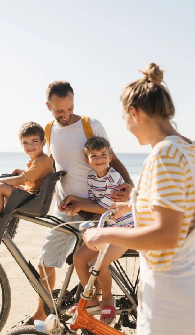 A family enjoys a sunny beach day, riding bikes and sharing smiles, highlighting local outdoor activities.