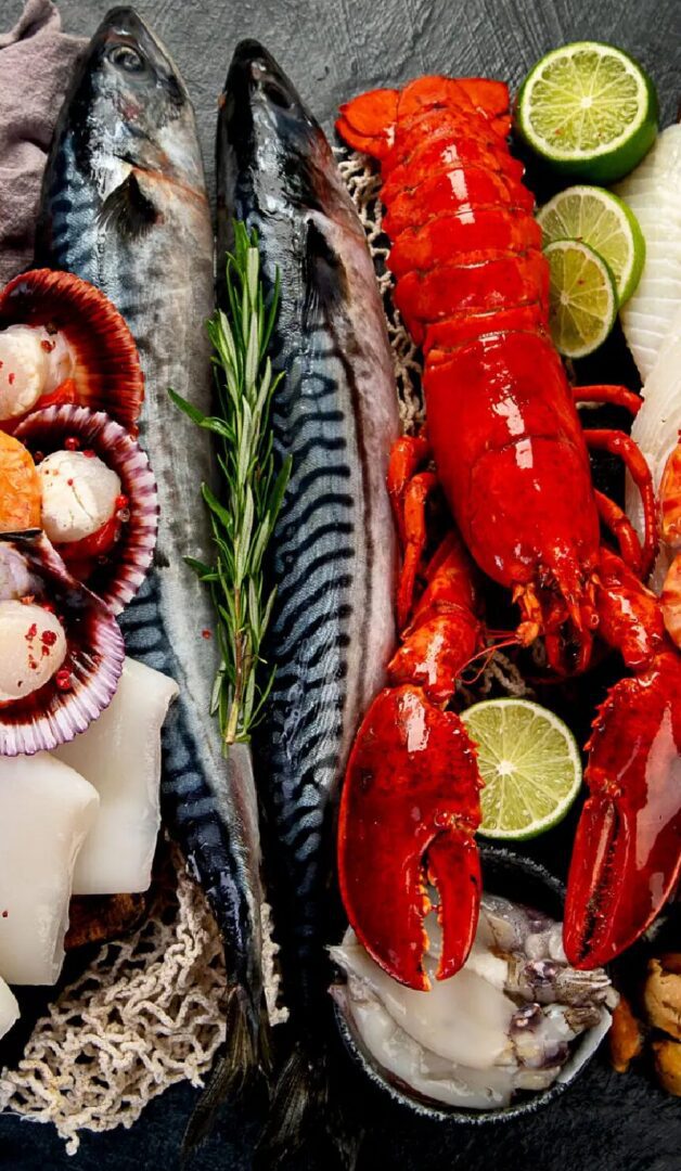 Fresh seafood assortment featuring fish, lobster, scallops, and lime, highlighting local culinary offerings.